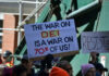 Protesters holding signs including The War on DEI