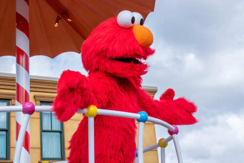 shutterstock_1558685735.jpg Elmo character on a parade float under an umbrella