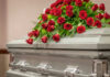 Casket with red roses on top