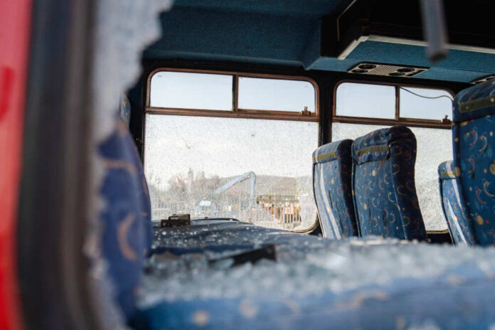 shutterstock_1519765706.jpg Interior of a damaged bus with broken windows and scattered glass
