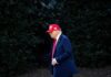 A man in a red hat and suit walking outdoors