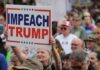 A crowd at a protest holding a sign that says 'IMPEACH TRUMP'