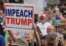 A crowd at a protest holding a sign that says 'IMPEACH TRUMP'
