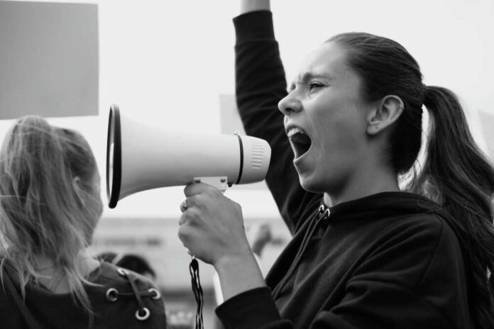 Person shouting into megaphone at protest rally