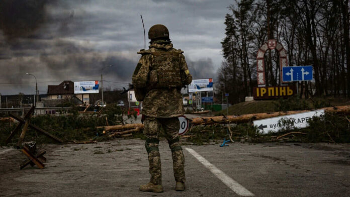 Soldier standing before barricaded road with smoke background