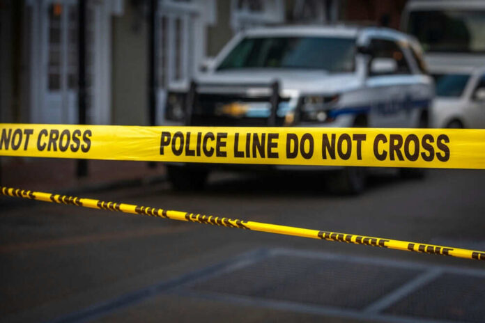 Yellow police tape in front of blurred vehicles