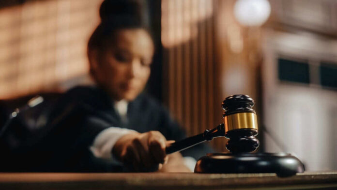 Judge holding gavel in courtroom setting
