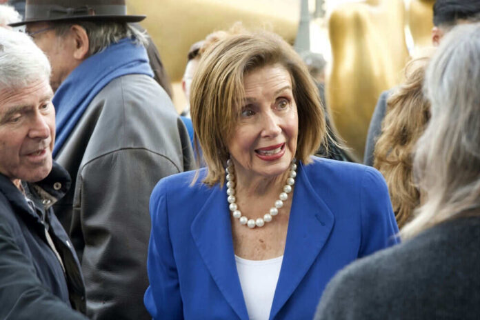 Woman in blue blazer speaking to people outside