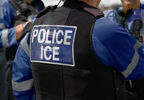 Close-up of a police officers uniform with POLICE ICE on the back
