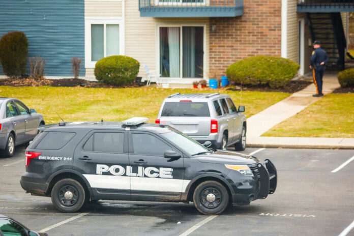 Police car parked near residential building officers nearby