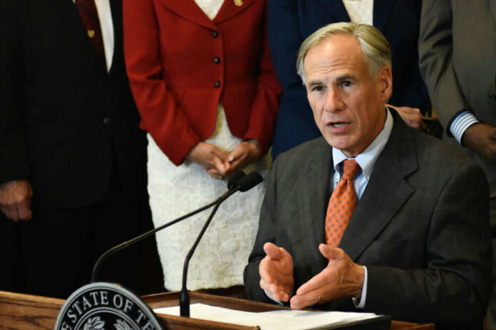 Man speaking at a podium with others behind him