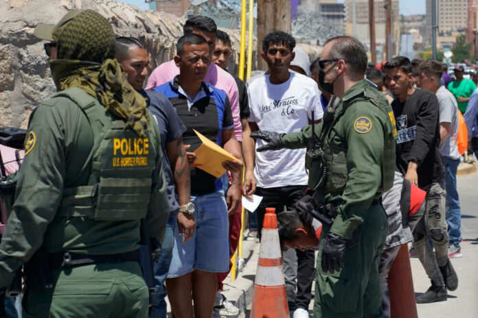 Border officers interacting with a group of people
