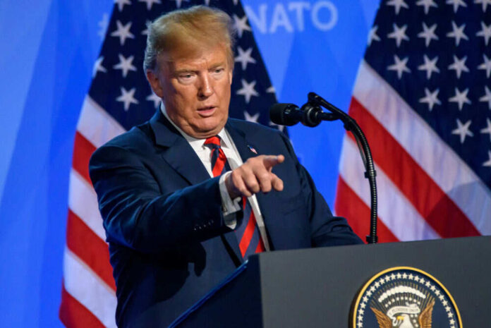 Man in suit pointing during a speech at NATO event
