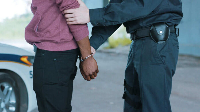 Police officer arresting a person outdoors