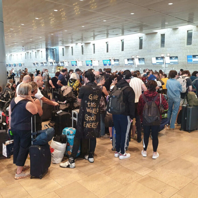 Crowded airport checkin area with many passengers waiting