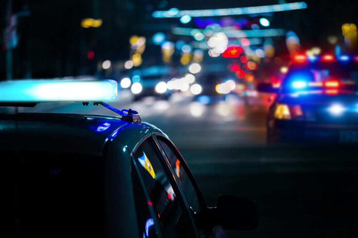Police car with flashing lights at night roadside