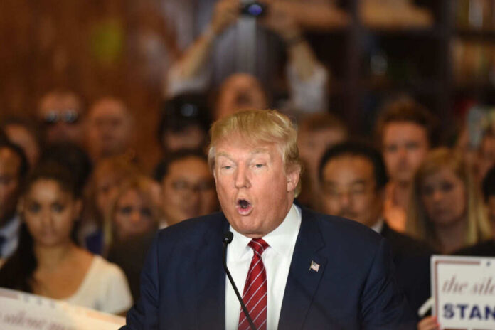 Man speaking at a crowded event with microphone