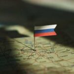 A small Russian flag pinned on a map