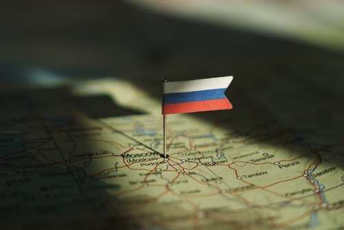 A small Russian flag pinned on a map