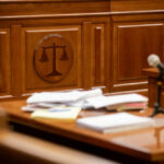 Explosive Trial Twist – Actor’s Shocking Move Courtroom desk with papers and microphone visible