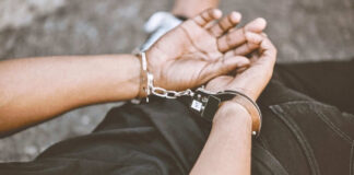 Person handcuffed lying on the ground outdoors