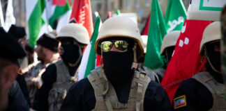 Soldiers in formation with flags and helmets visible