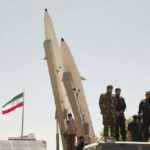 Brief Calm SHATTERED—Iran Conflict Triggers Price Explosion Missiles on display with soldiers and Iranian flag