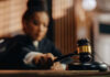 Judge holding gavel in courtroom setting