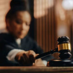 Court Shutdown Looms Over “Alligator Alcatraz” Judge holding gavel in courtroom setting